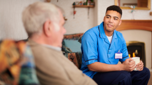 Elderly man receiving care from care professional