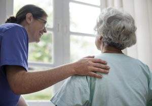 Care home nurse taking care of an elderly woman